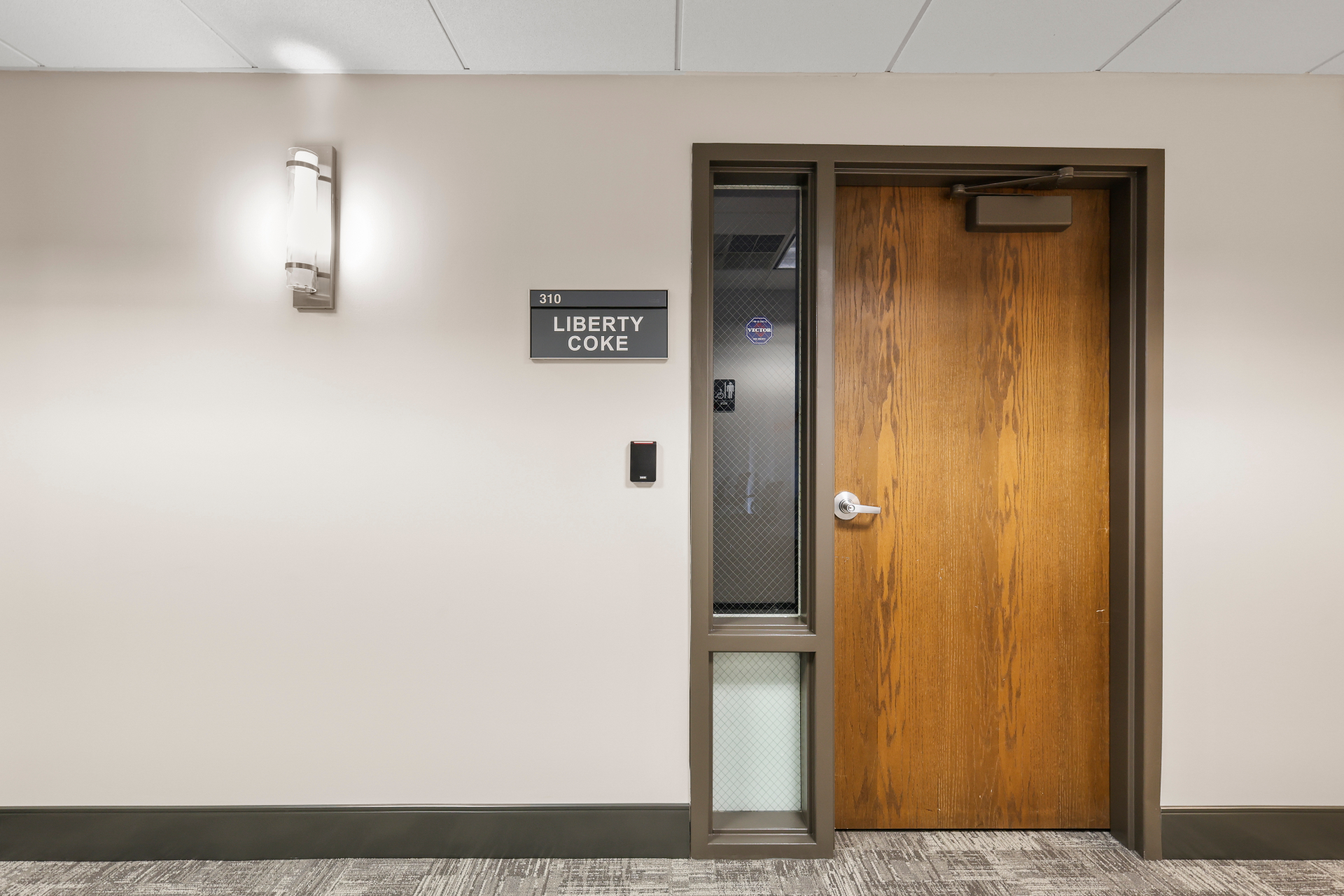 Office suite entry with signage, card access, and refreshed finishes