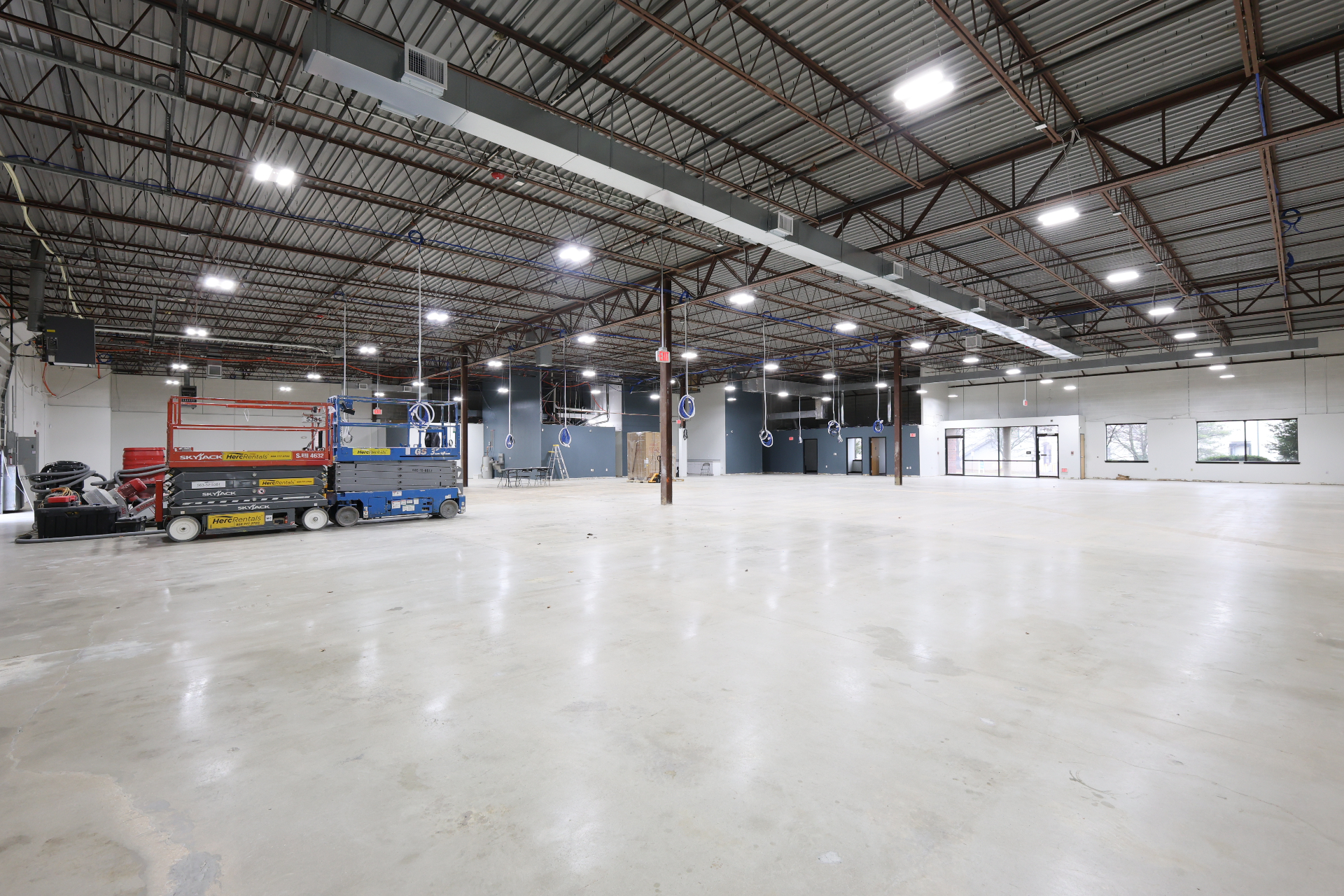 Open warehouse floor with storefront glazing and rough-in coils overhead