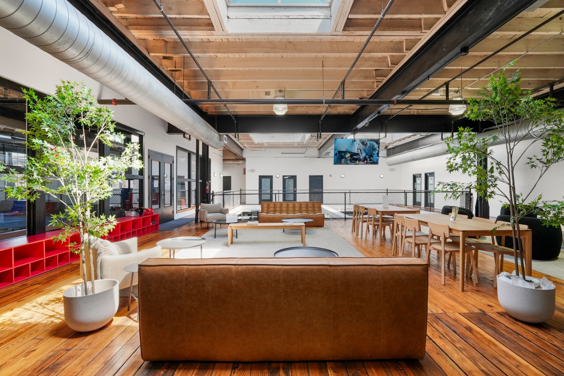 Mezzanine lounge with leather sofas, wood floors, and skylights